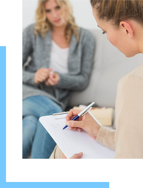 Counselor writing on a clip board during an intensive outpatient addiction treatment session