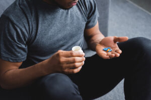 cropped view of african american man taking pills at home - meth vs adderall