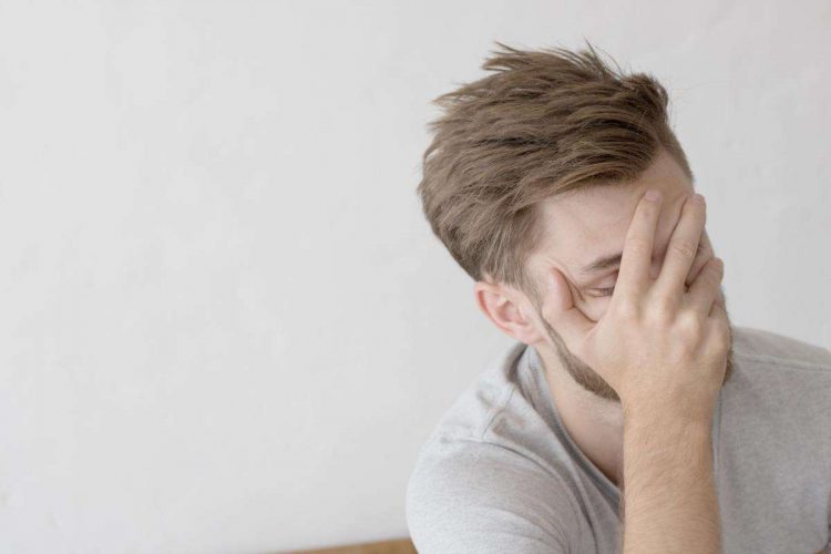 Man hides face after blackout drinking